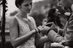 Groom putting a ring on his bride's fingers